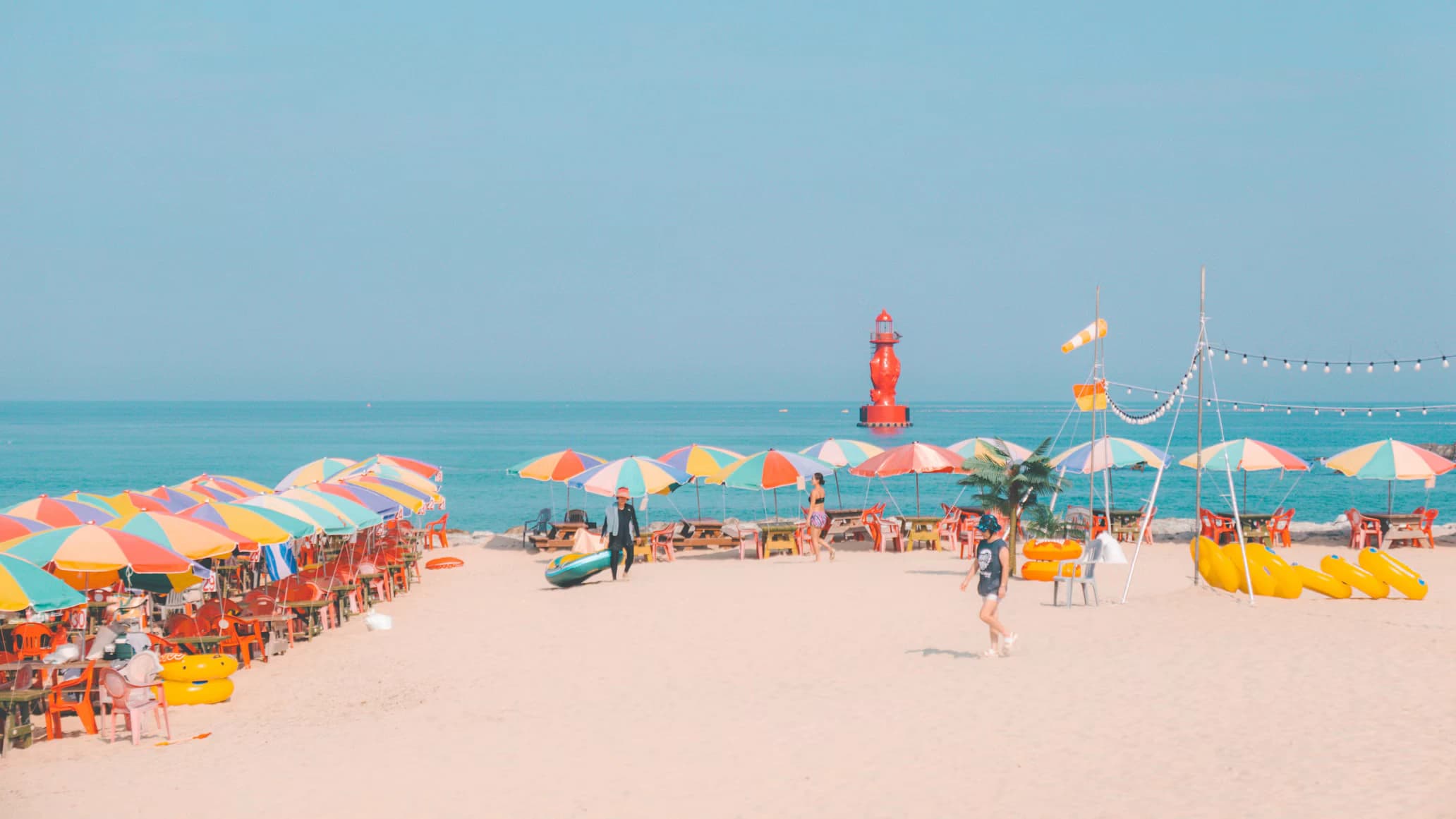 Fila di ombrelloni e lettini ordinati su una spiaggia italiana vista mare durante una giornata di sole